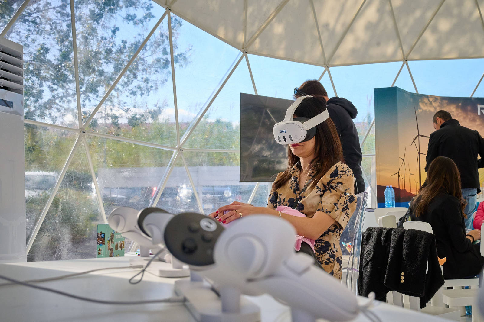 Una donna partecipa a un'esperienza di realtà virtuale all'interno di una struttura a forma di cupola con ampie finestre, illuminata.